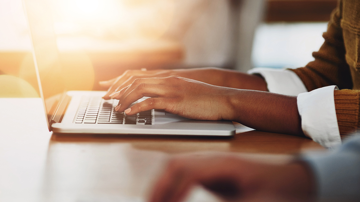 Henkilö kirjoittaa läppärillä.