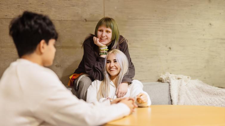 Joukko nuoria juttelee rennosti toistensa kanssa.