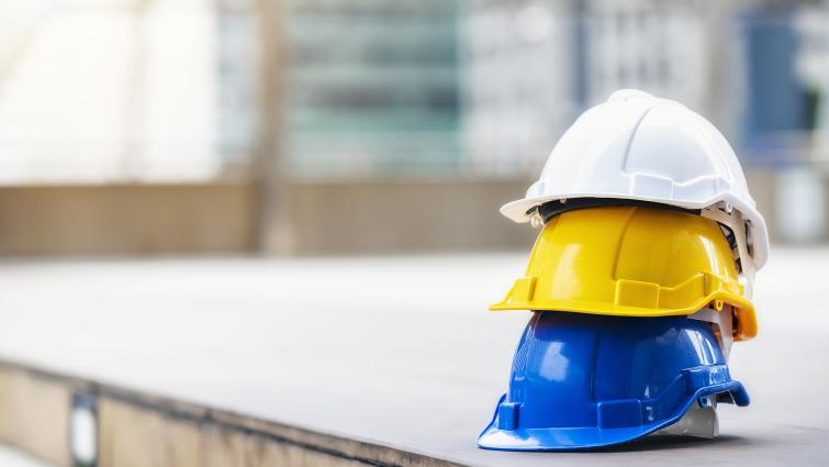 Turvakypäriä pinossa rakennustyömaalla.