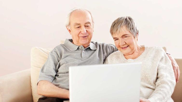 Kaksi eläkeläistä tutkii eläketietojaan tietokoneella. Kuva: Pixhill.