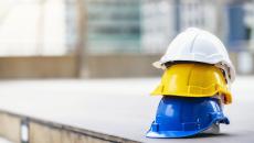 Turvakypäriä pinossa rakennustyömaalla.