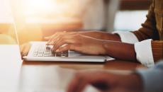 Henkilö kirjoittaa läppärillä.