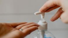 Työntekijä käyttää käsidesiä käsien puhdistamiseksi. Kuva:  Kelly Sikkema / Unsplash.