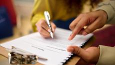 Kaksi ihmistä tutkii sopimuspapereita.